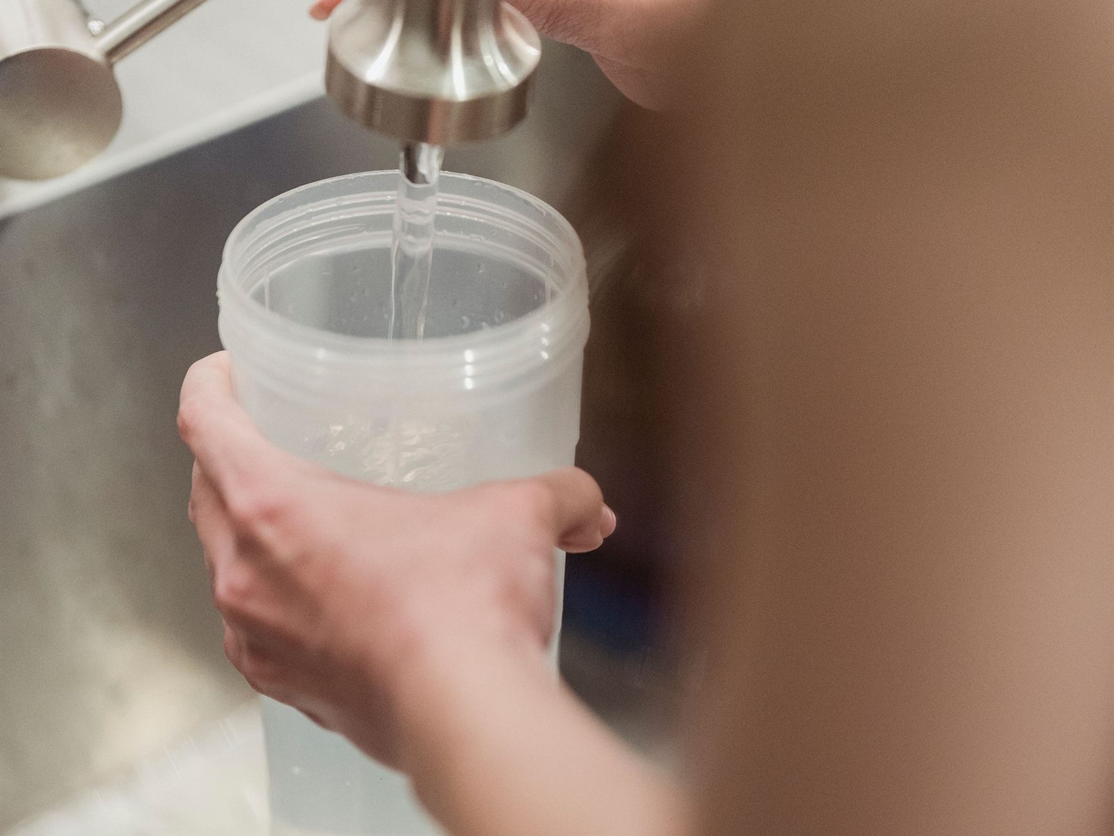Filling a reusable bottle at a kitchen pull-down faucet