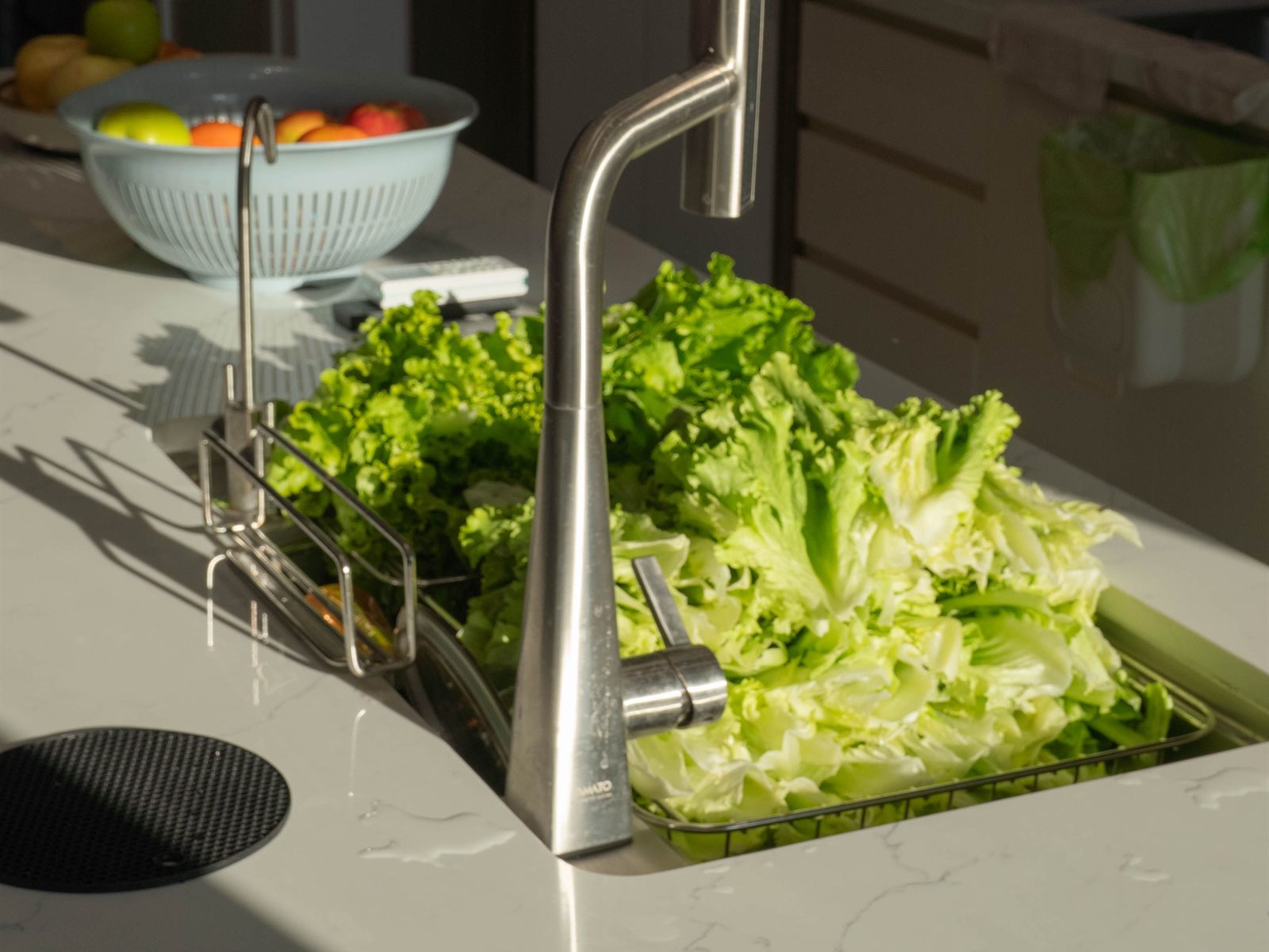 Fresh lettuce rinsed in a kitchen island sink with a filtered-water faucet